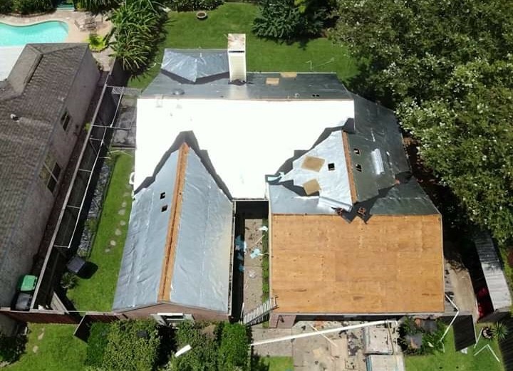 Aerial view of a roof re-deck in progress with plywood sheathing exposed