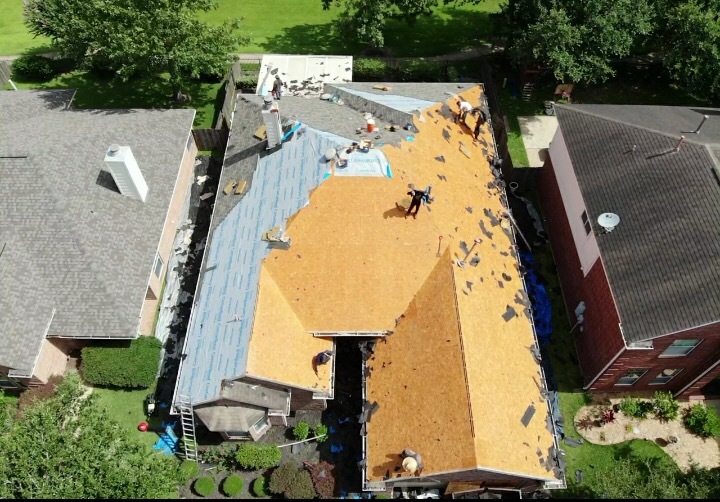 Aerial view of a roof tear-off with exposed plywood decking