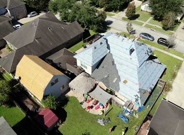 Aerial view of a roof re-deck with underlayment installed above a backyard play area