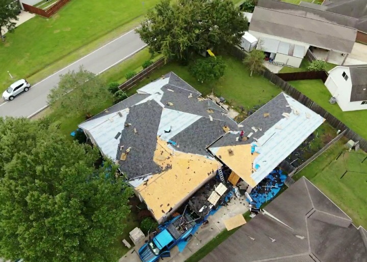 Aerial view of a roof mid tear-off with deck partially exposed